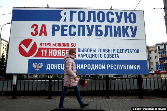 UKRAINE -- A woman walks past an election campaign billboard for elections in areas of eastern Ukraine held by Russia-backed separatists, on a street in Donetsk, November 7, 2018.