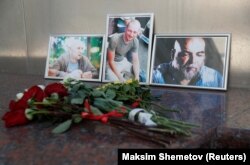 RUSSIA -- Photographs of journalists, (Right to left) Orhan Dzhemal, Kirill Radchenko and Aleksandr Rastorguyev, who were recently killed in Central African Republic by unidentified assailants, are on display outside the Central House of Journalists in Moscow, Augu