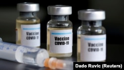 Small bottles labeled with a "Vaccine COVID-19" sticker and a medical syringe are seen in this illustration taken April 10, 2020.