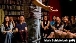 In this May 24, 2015 photo, audience laugh as a standup comedian performs during a comedy show at a bookstore in Beijing. Western-style standup comedy is a small yet growing scene in China that reflects wider changes toward more cultural freedom. (AP/Mark Schiefelbein)