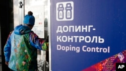 A man walks past a sign reading "Doping Control" at a 2014 Sochi Winter Olympics site in Krasnaya Polyana, Russia. Feb. 21, 2014. Moscow has been under fire for months over allegations of state-run doping. (AP Photo/Lee Jin-man)