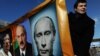 Opposition activists hold a banner with portraits of Russian Prime Minister Vladimir Putin, former Libyan leader Muammar Qaddafi and Belarus President Alexander Lukashenko at a rally in Pushkin Square, Moscow, in March of 2011. (AFP)