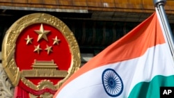 An Indian national flag is flown next to the Chinese national emblem (AP/Andy Wong)