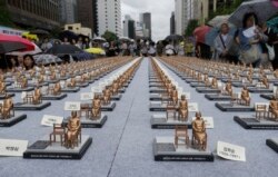 Comfort women statue miniatures are displayed to mark the 5th International Memorial Day for Comfort Women in Seoul, South Korea, Monday, Aug. 14, 2017.