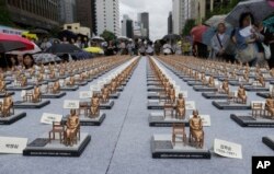 Comfort women statue miniatures are displayed to mark the 5th International Memorial Day for Comfort Women in Seoul, South Korea, Monday, Aug. 14, 2017.