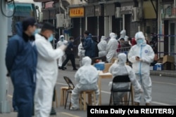 Workers in protective suits help residents in their transfer to a quarantine facility following new infections of the coronavirus disease (COVID-19), near Renji Hospital Affiliated with Shanghai Jiao Tong University Medical School in Shanghai on January 21, 2021.(Reuters)