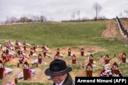 KOSOVO -- A man walks past the gaveyards at the cemetery in Krusha e Madhe, March 26, 2019