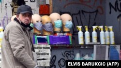 A grey market salesman sells face masks and hand sanitiser at a street corner in Sarajevo