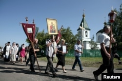 Ukraine -- People take part in a procession to attend a commemoration ceremony near the site of the Malaysia Airlines flight MH17 plane crash in the village of Hrabove in the Donetsk region, July 17, 2015