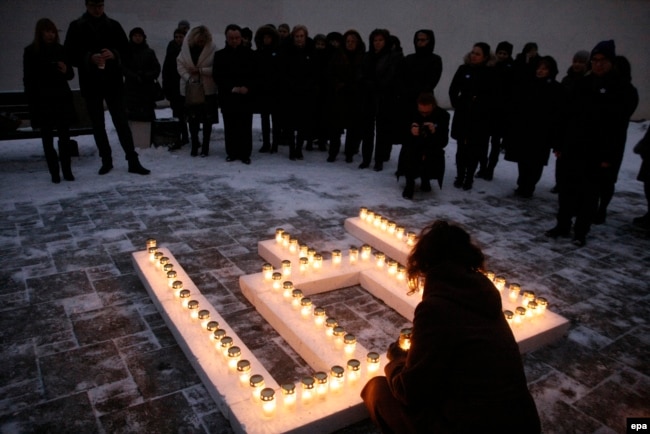 Lithuania -- Commemorating the victims of the Soviet aggression of 13 January 1991, people place lit candles in the shape of the Columns of Gediminas outside the Ministry of Education and Science in Vilnius, January 12, 2017