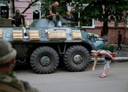 Ukraine -- A local woman greets Ukrainian soldiers in central Slovyansk, July 15, 2014