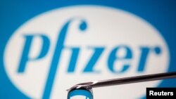 Pfizer's logo is reflected in a drop on a syringe needle in this illustration taken November 9, 2020. REUTERS/Dado Ruvic/Illustration/File Photo