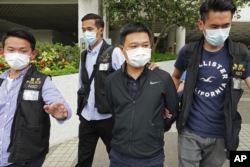 Ryan Law (second from right), Apple Daily's chief editor, is arrested by police officers on June 17, 2021. AP