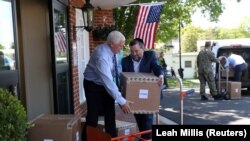 U.S. Vice President Mike Pence unloads boxes of personal protective equipment (PPE) with Norman Rokeach, CEO of Marquis Health Services, while helping to deliver a shipment that was provided by the Federal Emergency Management Administration (FEMA) to the