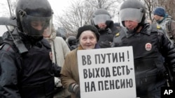 Policemen detain a participant of an unauthorized rally by the Open Russia movement opposing President Putin's run in the 2018 presidential elections, St. Petersburg, April 29, 2017. A poster reads 'Putin, there is a way out – retirement!’