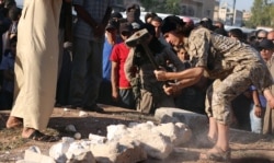An image made available by propaganda Islamist media outlet Welayat Halab on July 2, 2015 allegedly shows an Islamic State fighter destroying ancient artifacts smuggled from the Syrian city of Palmyra. (AFP)