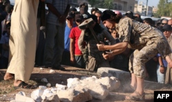 An image made available by propaganda Islamist media outlet Welayat Halab on July 2, 2015 allegedly shows an Islamic State fighter destroying ancient artifacts smuggled from the Syrian city of Palmyra. (AFP)