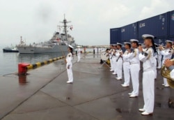 A Chinese military band plays as the guided missile destroyer U.S.S. Benfold arrives at port in Qingdao on August 8, 2016.