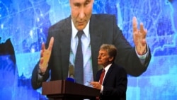 Kremlin spokesman Dmitry Peskov looks on as Russian President Vladimir Putin speaks via video call during a news conference in Moscow, on December 17, 2020. (Alexander Zemlianichenko/Associated Press)
