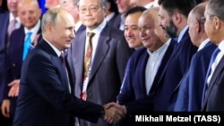 RUSSIA – Russia's President Vladimir Putin greets Rossiya Segodnya director general Dmitry Kiselyov, RIA Novosti Ukraine editor-in-chief Kirill Vyshinsky (L-R middle). Sochi, October 3, 2019