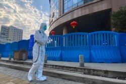 A worker in protective clothing carrying disinfecting equipment walks outside Wuhan Central Hospital. This photo was taken on February 6, 2021, in Wuhan.