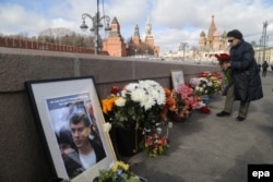 Russia -- A woman lays flowers at the place where Boris Nemtsov was killed before a memorial march for Nemtsov to mark the second anniversary of his murder, in Moscow, February 26, 2017