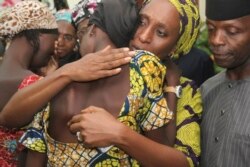 Nigerian Vice President Yemi Osinbajo looks on while his wife Dolapo comforts a Chibok girl freed from Boko Haram, October 13, 2016. (AFP)