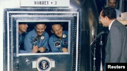 From left: The Apollo 11 astronauts, Neil Armstrong, Michael Collins, and Edwin Aldrin Jr. are met by Former U.S. President Richard M. Nixon while in mobile quarantine aboard the U.S.S. Hornet in the Pacific Ocean in July 1969. 