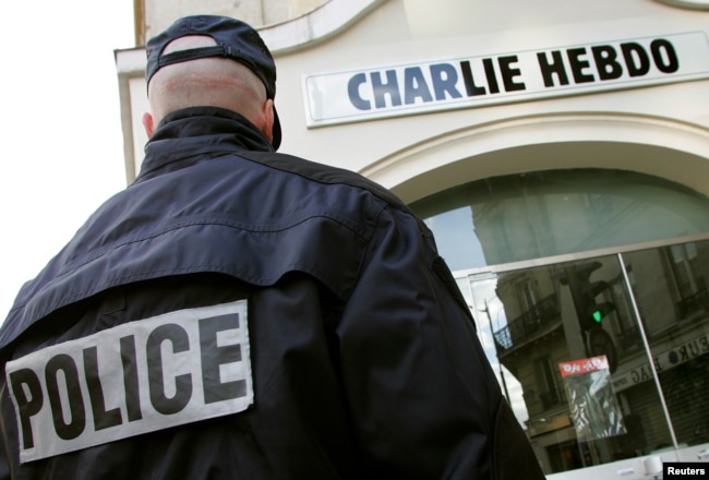 A policeman stands guard outside the French satirical weekly Charlie Hebdo in Paris, Feb. 9, 2006, after the publication reprinted cartoons of the Prophet Muhammad and published one of its own on its front page.