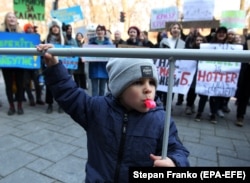 UKRAINE -- A child blows a whistle during the 'Global Climate Strike for future' protest, in front the Cabinet of Ministers building in Kyiv, March 15, 2019
