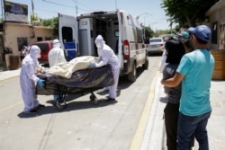 Paramedics transport the body of a man who died of the coronavirus disease (COVID-19) before being transferred to a hospital as his relatives observe, in Ciudad Juarez, Mexico May 26, 2020.
