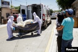 Paramedics transport the body of a man who died of the coronavirus disease (COVID-19) before being transferred to a hospital as his relatives observe, in Ciudad Juarez, Mexico May 26, 2020.