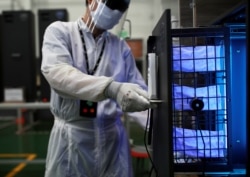 A worker in protective suit shows a UVC sterilizer unit for medical staff, during the COVID-19 outbreak, at a factory in Samutprakarn, Thailand April 15, 2020.