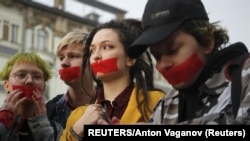 RUSSIA -- Activists from the local LGBT community put tape over their mouths while walking during a protest against discrimination in St. Petersburg, April 17, 2019