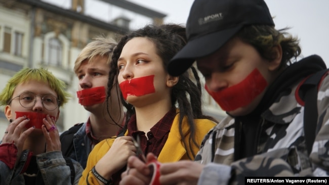 RUSSIA -- Activists from the local LGBT community put tape over their mouths while walking during a protest against discrimination in St. Petersburg, April 17, 2019