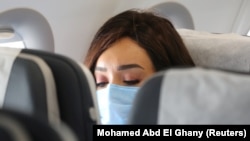 FILE PHOTO: A traveller wears a protective face mask on a plane, following an outbreak of the coronavirus disease (COVID-19), at Cairo International Airport in Cairo, Egypt, June 18, 2020.