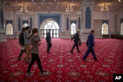Officials accompany foreign journalists during a visit to the Xinjiang Islamic Institute in Urumqi on April 22, 2021. AP/Mark Schiefelbein