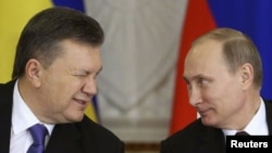 Then-Ukrainian President Viktor Yanukovych (left) gives a wink to Russian President Vladimir Putin during a signing ceremony after a meeting of the Russian-Ukrainian Interstate Commission at the Kremlin in Moscow, December 17, 2013. REUTERS/Sergei Karpukhin