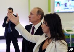 Russian President Vladimir Putin and RT's Editor-in-Chief of RT Margarita Simonyan attend an exhibition marking RT's 10th anniversary in Moscow, December 10, 2015