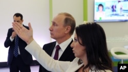 Russian President Vladimir Putin and RT's Editor-in-Chief of RT Margarita Simonyan attend an exhibition marking RT's 10th anniversary in Moscow, December 10, 2015