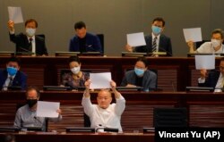 Pro-democracy lawmakers raise white papers to protest during a meeting to discuss the new national security law at the Legislative Council on July 7, 2020. AP/Vincent Yu