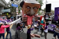 Activists destroy an effigy of Duterte during a rally near the Malacanang presidential palace to mark International Women's Day on Monday, March 8, 2021 in Manila.