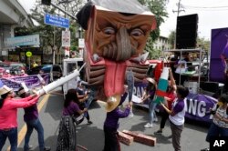 Activists destroy an effigy of Duterte during a rally near the Malacanang presidential palace to mark International Women's Day on Monday, March 8, 2021 in Manila.