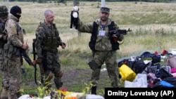 UKRAINE – A pro-Russian fighter holds up a toy found among the debris at the crash site of a Malaysia Airlines jet near the village of Hrabove, Donetsk region, July 18, 2014