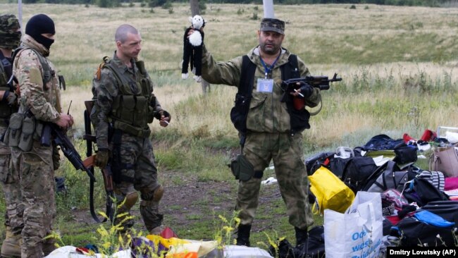 UKRAINE – A pro-Russian fighter holds up a toy found among the debris at the crash site of a Malaysia Airlines jet near the village of Hrabove, Donetsk region, July 18, 2014