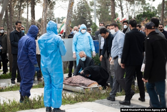 Virus Outbreak Mideast Iran -- Relatives mourn over the body of Fatemeh Rahbar, a lawmaker-elect from a Tehran constituency, who died on Saturday after being infected with the new coronavirus, at Behesht-e-Zahra cemetery, just outside Tehran, Iran, Sunday