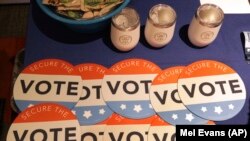 U.S. -- Computer mouse pads with Secure the Vote logo on them are seen on a vendor's table at a convention of state secretaries of state in Philadelphia, July 14, 2018