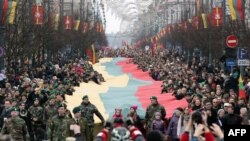 Lithuania -- Lithuanians march with a national flag during a parade to mark the 25th anniversary of the independence from the Soviet Union in Vilnius, March 11, 2015