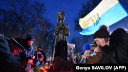 UKRIANE -- People lay symbolic sheaves of wheat and light candles during a commemoration ceremony at a monument to victims of the Holodomor famine of 1932-33 in Kyiv on November 24, 2018.