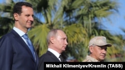 SYRIA -- (Left to right) Syrian President Bashar al-Assad, Russian President Vladimir Putin and Russian Defense Minister Sergei Shoigu visit the Hmeimim military base in Latakia Province, December 11, 2017